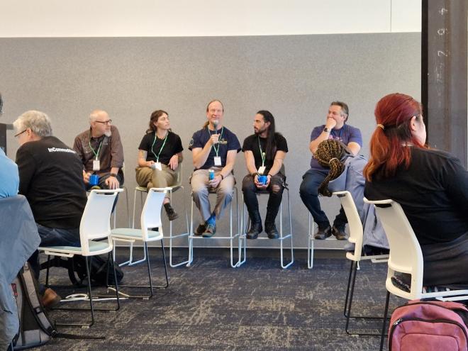 The steering council: Barry, Emily, Greg with a microphone, Pablo and Thomas sitting on high stools.