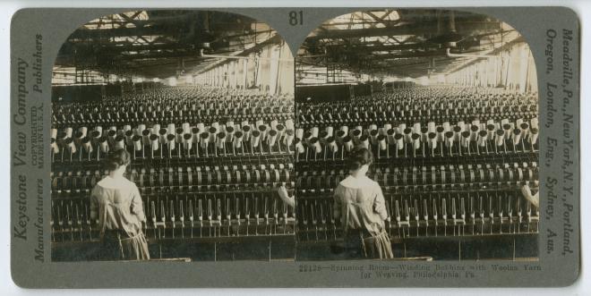 View of the spinning room of a wool cloth manufacturing factory on Broad Street in Philadelphia, late nineteenth-century. Shows two women operating machines that wind bobbins with woolen thread for weaving.