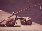 A fishing rod with a bell on it propped up over water