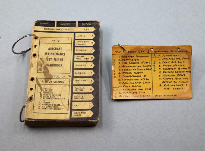 An AH-1G Aircraft Maintenance Test Flight Handbook and handwritten checklist for rotary wing helicopters from 1971-1972. Both handbooks are bound with metal rings.