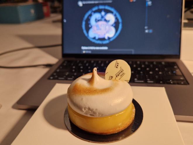 A circular lemon meringue pie in front of a Mac showing the release logo.